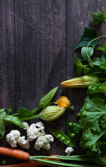 Cauliflower with vegetables and spices on a dark wood background