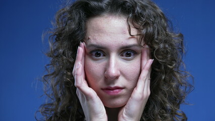 Stressed overwhelmed young woman trying to sooth her nervousness by putting hands on the side of...