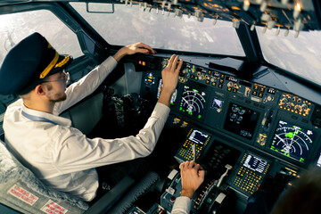 young pilots in the cockpit of the plane control air transport during a long distance flight simulator - obrazy, fototapety, plakaty
