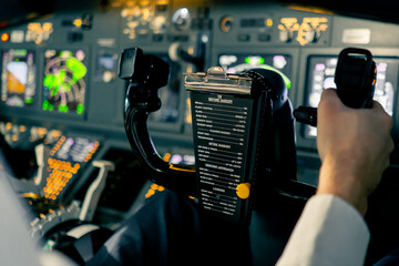 close-up Pilot in the cockpit of an airplane holding a rotary steering wheel during a flight Air...