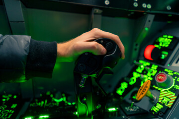 close-up of the cockpit of a military plane a pilot with a steering wheel and many buttons on the...