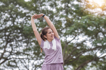 Young Asian woman takes care of her health by exercising. Stretch your legs in the park