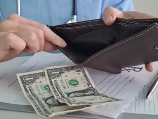 Poor doctor showing empty wallet with one dollar