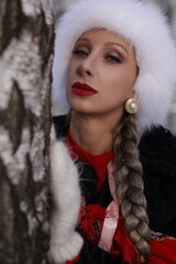 Woman with big braid in brown retro fur coat in winter street with snow. Winter cold weather. Girl...