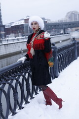 Woman with big braid in brown retro fur coat in winter street with snow. Winter cold weather. Girl...