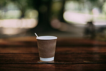 cardboard coffee cup on the table with nice bokeh and colors - 692015938