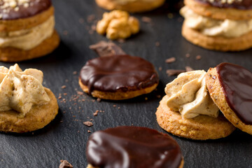 Round nut cookies with coffee and nut cream. Delicious dessert with chocolate, hazelnut praline and coffee