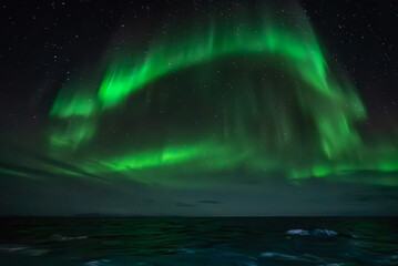 Green northern light, aurora borealis above sea - 692016923