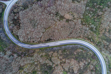 aerial view of a winding road on a mountain with a forest in wintertime