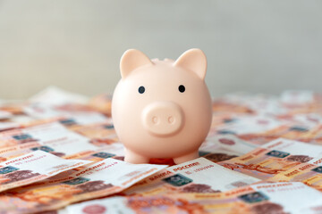 Pink piggy bank with Russian money banknotes currency rouble in nominal value of five thousand....