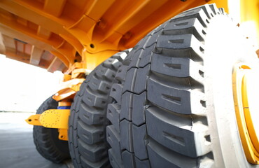 Huge rear wheels of dump truck at unusual angle closeup