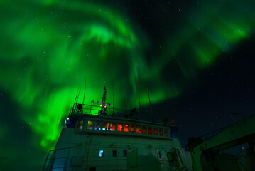 Green northern light, aurora borealis above big boat at night - 692024165