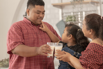 A chubby family with a father wearing a prosthetic. They were happily inviting their girl to drink...