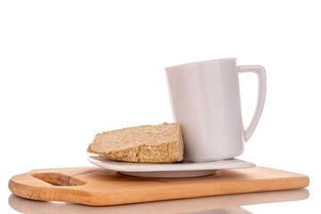 One piece of sweet halva on a white ceramic saucer with a cup, macro, isolated on a white background.