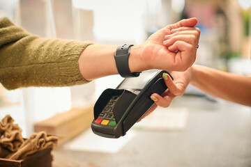 Close Up Of Customer In Store Making Contactless Payment With Smart Watch