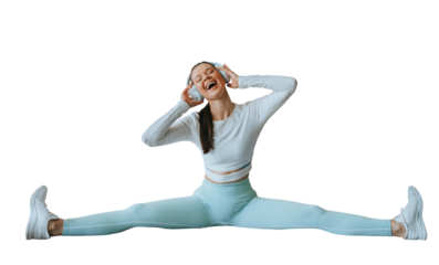 Happy brunette American girl in sportswear stretching at fitness using headphones sings song. Fit caucasian young woman enjoying training against transparent background, Youth, strength. Health