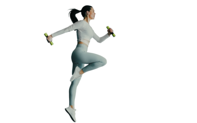 Fit caucasian young woman in blue sportswear makes jumps holds dumbbells against transparent background. Tall brunette European girl with ponytail doing sports. Healthy lifestyle.