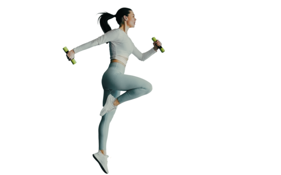 Fit caucasian young woman in blue sportswear makes jumps holds dumbbells against transparent background. Tall brunette European girl with ponytail doing sports. Healthy lifestyle.