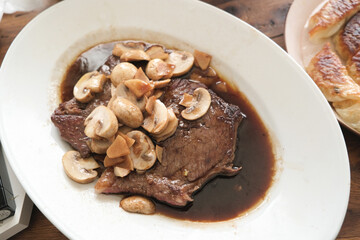 Beef steak with mushrooms on a white plate