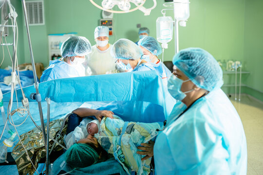 Surgical team finishes after caesarean section on woman after caesarian operation.