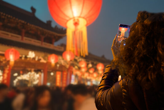 Back view of a tourist taking a picture with her smartphone at the Chinese Lantern Festival