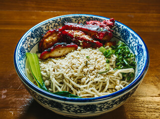 Chinese noodles filled with red pork meat and vegetables in a kopitiam style bowl