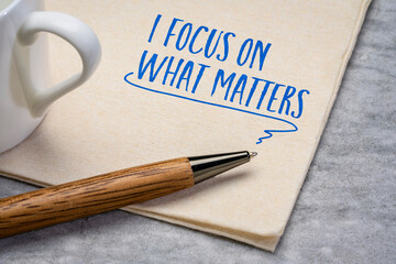 I focus on what matters - handwriting on a napkin with a cup of tea, self reminder