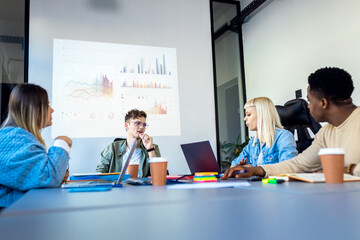 Diverse group of young business people working on new project together in office.