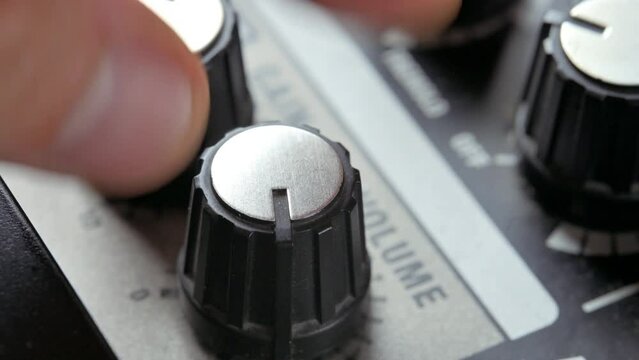 Man adjusting sound knobs on guitar amplifier. 4k video footage UHD 3840x2160