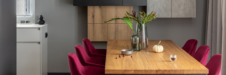 Close up on elegant details of dining room interior design. Velvet chairs, wooden table and...