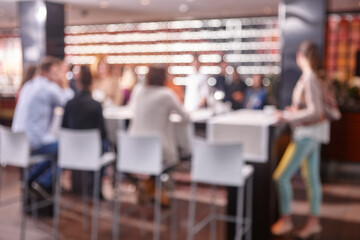 Out of focus effect. Restaurant interior with people. Seated persons