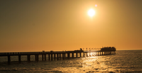 Swakopmund Pier with a beautiful Orange Sunset and silhouette of people on the pier