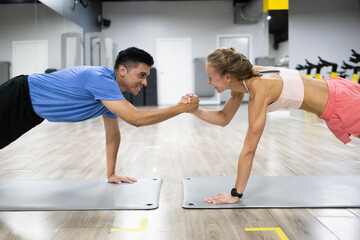 Fitness duo in plank position with motivational fist bump