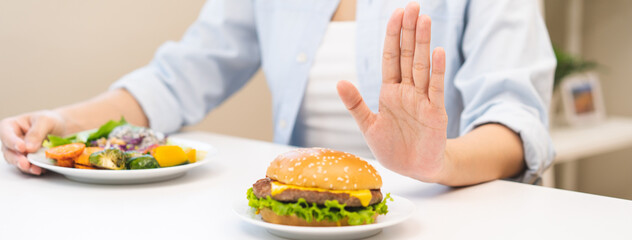 Diet concept, asian young woman hand reject eat burger, hamburger on plate, push out or deny to eat...