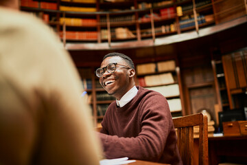 Smiling young man student in college library
