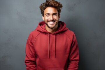 Streetwise charm. Captivating image of a fashionable guy with a sleek haircut and beard, donning a red hoodie against a weathered concrete wall. Generated AI - obrazy, fototapety, plakaty