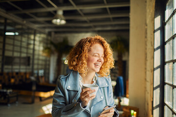 Happy young woman using smartphone in modern office