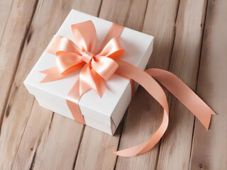 White gift box with peach ribbon on wooden background. Holiday present box, tied with wrapping ribbon.