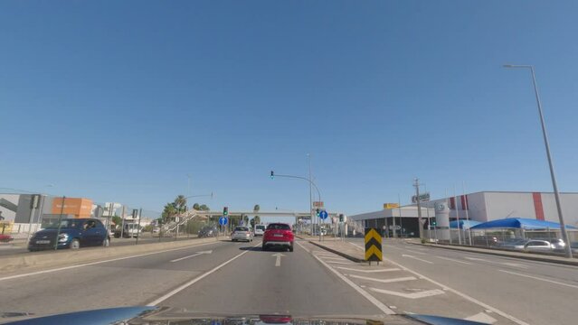 First person view, FPV, from dashcam of car driving along the Algarve Coast in Portugal, driving on the highway towards Faro. Road trip video in POV, with blue sky	