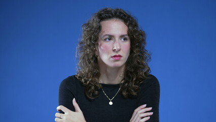 Anxious woman in her 20s feeling nervous and filled with anxiety standing in blue background with...