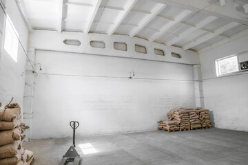 Warehouse room of an industrial building. Filled paper bags on pallets.