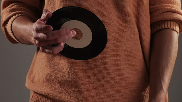 Retro Vinyl records in man hands close-up macro. Old disck for music. Retro vintage music player at home