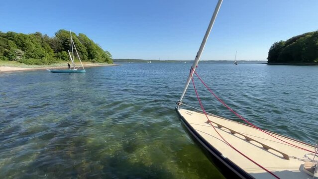Steady shot of sailboat anchoring in beautiful bay (Store Okseø or Ochseninsel) in the Baltic Sea