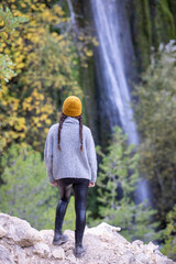 Young girl admiring waterfall in autumn - 692113134