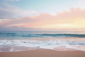 A serene ocean horizon at dusk with gentle waves lapping the shore. - obrazy, fototapety, plakaty