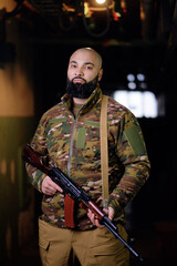 Portrait of the armed bearded man looking with a serious face straight at the camera