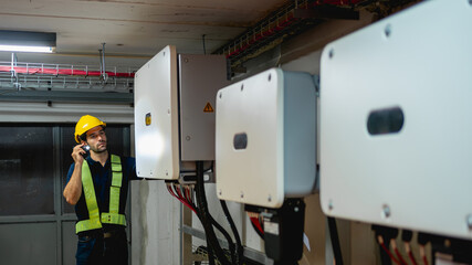 Technician Engineering setting inverter solar panel in electrical room. Service engineer installing...