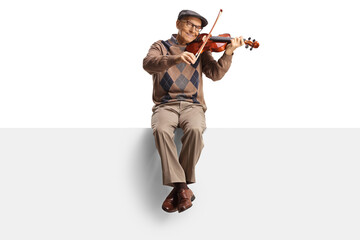 Elderly man sitting on a panel playing a violin and smiling