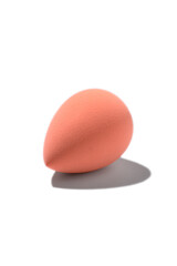 Pastel orange sponge for makeup on isolated on white background with dark shadow. Beauty blender.