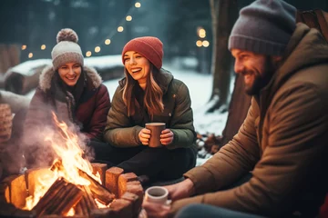 Poster Happy friends having fun and relaxing around fire pit. Winter party outside © colnihko